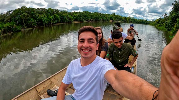 Homem em primeiro plano em barco no pantanal com pessoas atrás